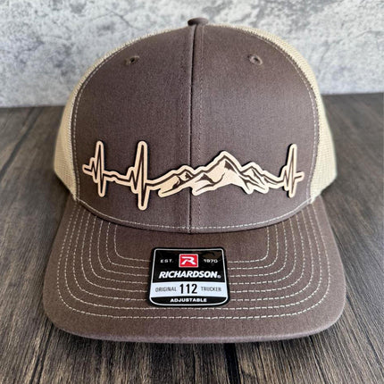 Close-up of leather patch with heartbeat and mountain design on Richardson 112 hat

