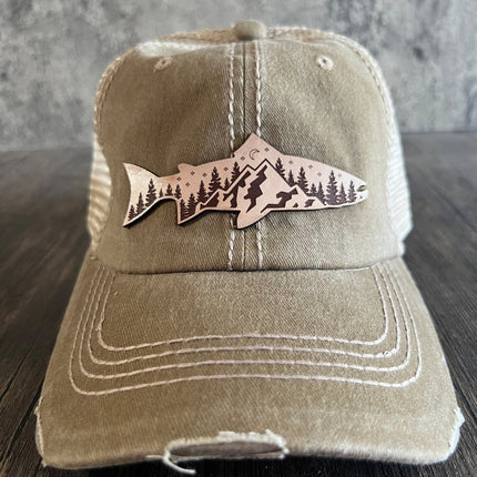 Close-up of engraved leather patch featuring mountain and fish design