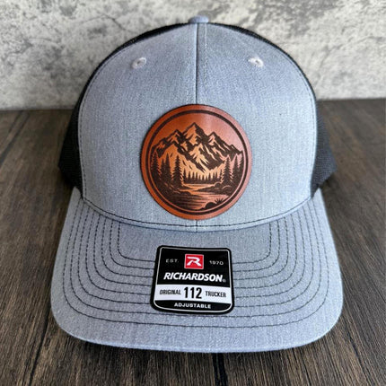 Close-up of hand-engraved mountain lake design on leather patch