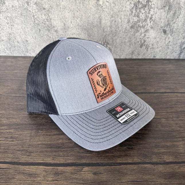 Surviving Fatherhood Hat, Leather Patch Dad Hat, Richardson 112 Trucker Cap, Funny Beer Dad Gift, Father's Day Hat - Patch Palooza
